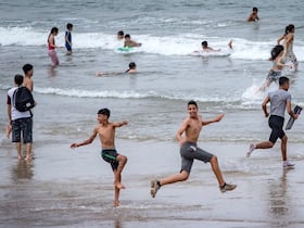 De jeunes baigneurs s'amusent sur une plage le long de la côte de la ville de Salé, au nord de Rabat, le 25 juin 2020.